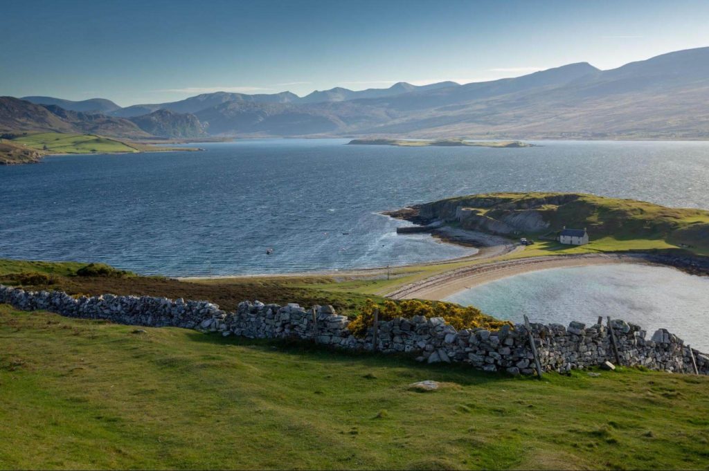 A view of distant mountains and blue sea from a bay in Scotland. Photo: Piotr Musio?