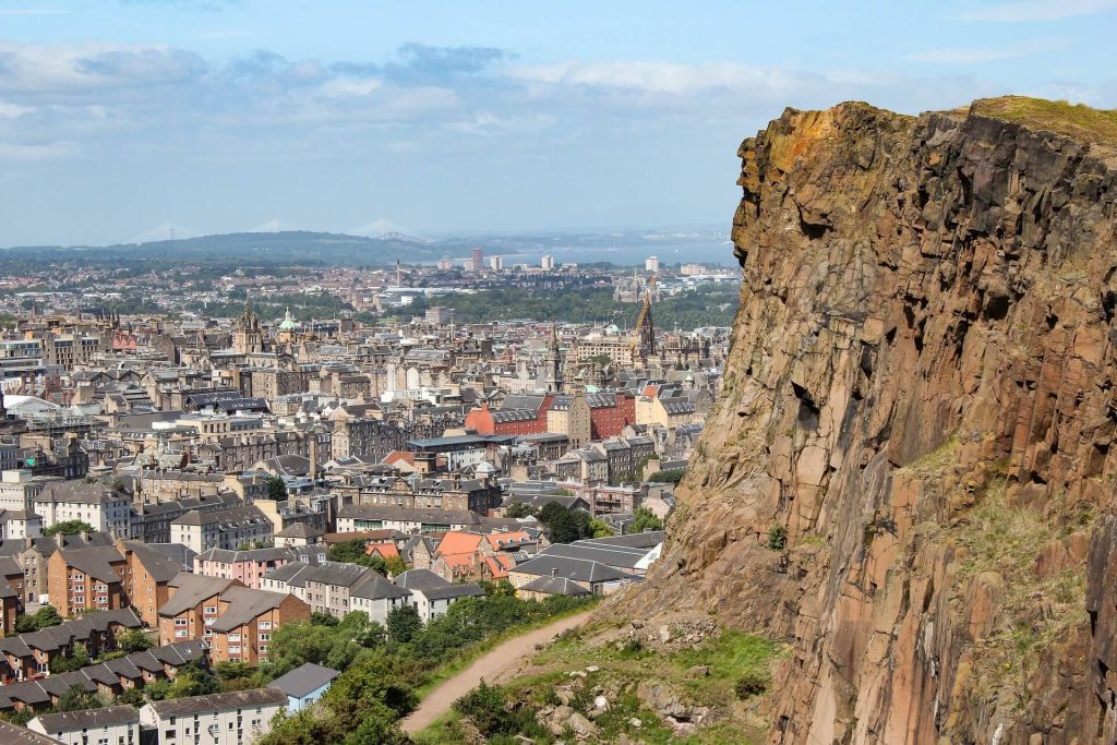 A brown mountaintop, footpath and city skyline